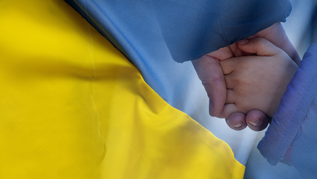 Mother holds a little girl by the hand against the background of the national flag of Ukraine yellow blue. Peace in Ukraine, stop the war